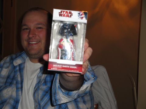 2000 Ford Crown Victoria - A man smiles while holding a festive Darth Vader bobblehead toy.