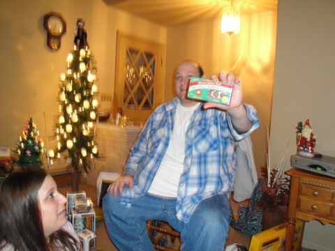 2000 Ford Crown Victoria - A man presents a box of "Happy Day" Meatball Bubble Gum in a festive holiday setting with Christmas trees.