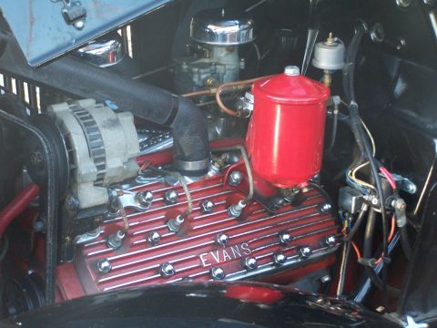 1990 Ford Bronco - The engine bay features a V8 engine with prominent red valve covers displaying the 'EVANS' brand name.