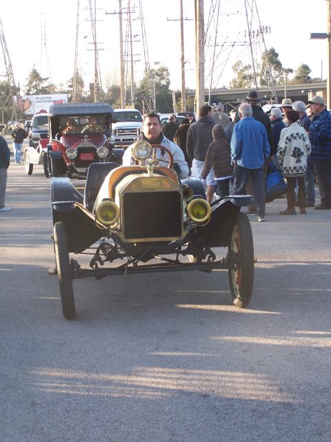 1990 Ford Bronco - A man drives a vintage Ford Model T during an outdoor car show event.