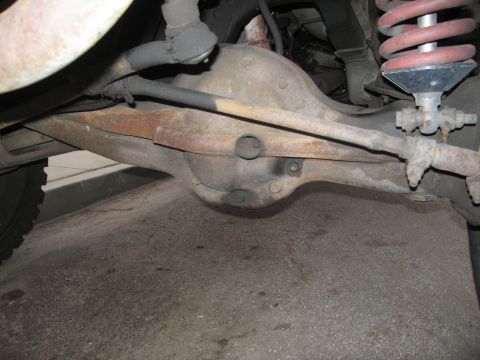 1986 Ford Bronco - Close-up view of rear axle and suspension components, with a watermark for SUPERMOTORS.NET.