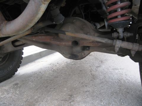 1986 Ford Bronco - Undercarriage view showing the rear axle assembly and suspension parts of a vehicle.