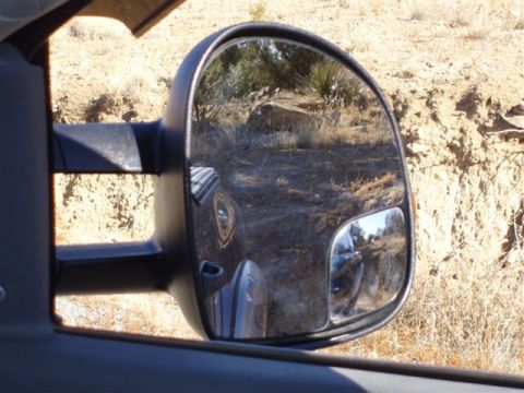 2007 Dodge 2500 - Reflection in the side mirror shows a vehicle driving through a dry, desert landscape.