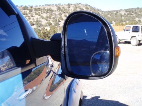 2007 Dodge 2500 - A close-up of a truck's side mirror shows a reflection of the surrounding arid landscape and another vehicle.