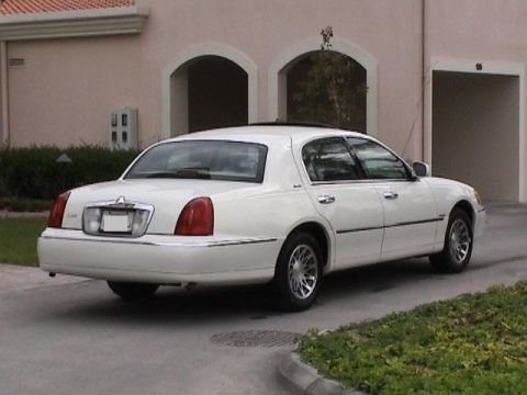 2002 Lincoln Town Car - Rear view of a white 2002 Lincoln Town Car parked in front of a building.