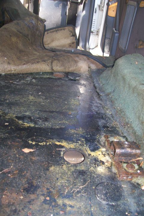 1992 Ford C-350 (Centurion Conversions) - The interior floor of a vehicle shows significant wear and staining.