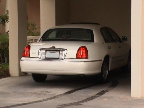 2002 Lincoln Town Car - Rear view of a white 2002 Lincoln Town Car parked under a covered area.
