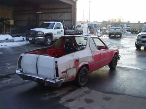 1972 Ford Ranchero - This project vehicle shows significant body damage and is in primer, parked outdoors.