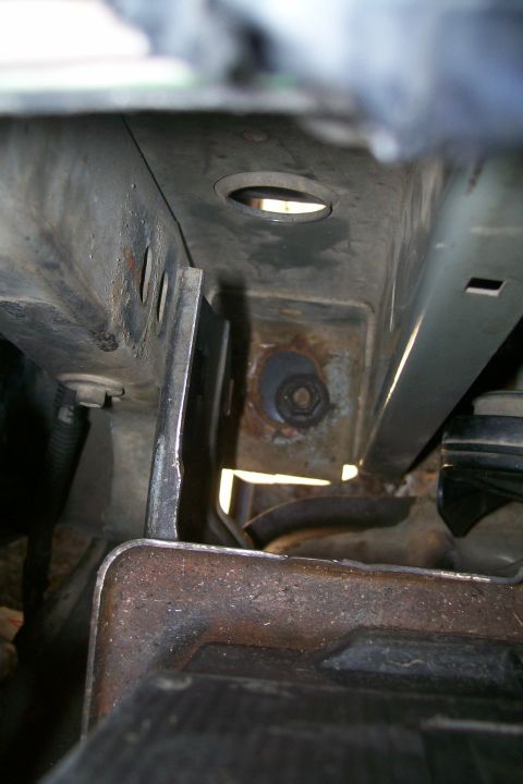 1992 Ford C-350 (Centurion Conversions) - This image shows a close-up view of rusty metal frame and suspension components, possibly related to a body lift modification.