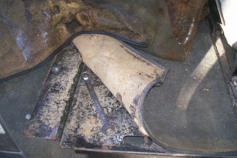1992 Ford C-350 (Centurion Conversions) - A wrench rests on the floor of a vehicle, next to a damaged interior mat.