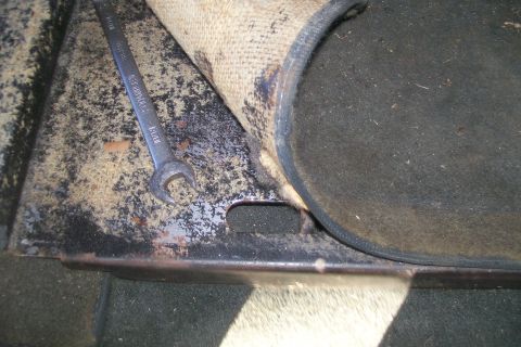1992 Ford C-350 (Centurion Conversions) - A wrench rests on a metal surface with carpet, suggesting interior vehicle work.