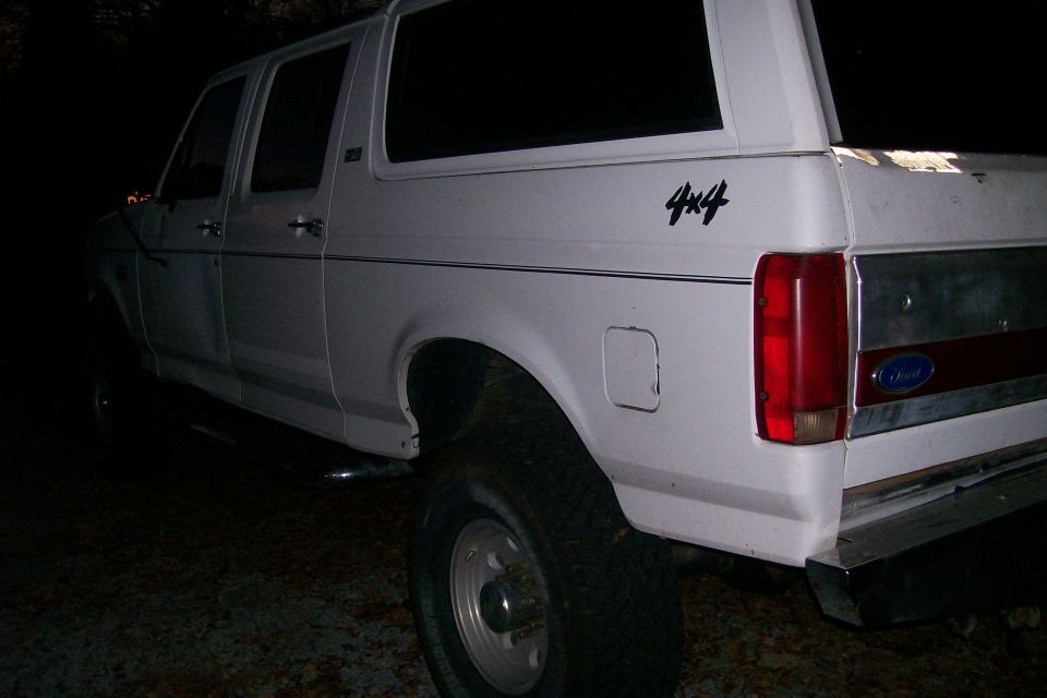 White 4x4 SUV, rear view. "4x4" decal visible