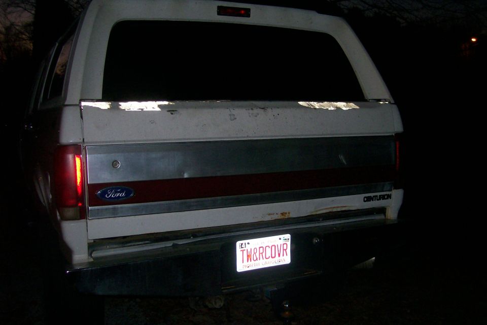 Rear tailgate of white Ford Centurion at night with TW&RCOVR North Carolina plate