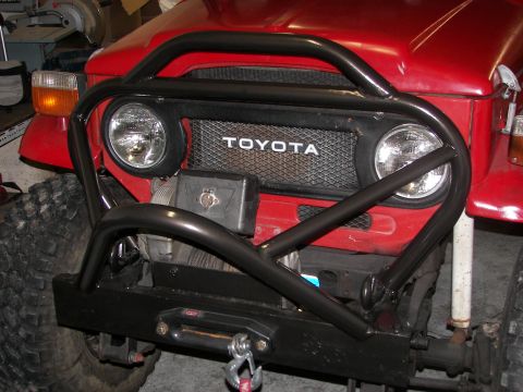 1990 Chevrolet Suburban - Front view of a red Toyota Land Cruiser FJ40 a prominent black bull bar, winch, and distinctive grille.