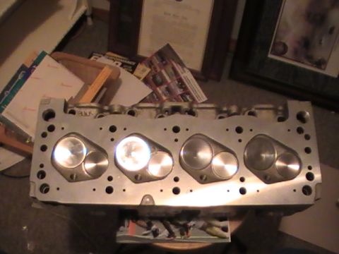 1971 Ford Mustang - Engine cylinder head with visible valve ports and bolt holes, part of a larger engine assembly.