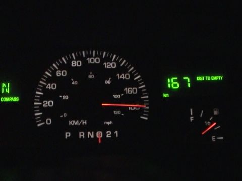 2002 Lincoln Town Car - The instrument cluster displays speed in KM/H, fuel level, and remaining distance to empty.