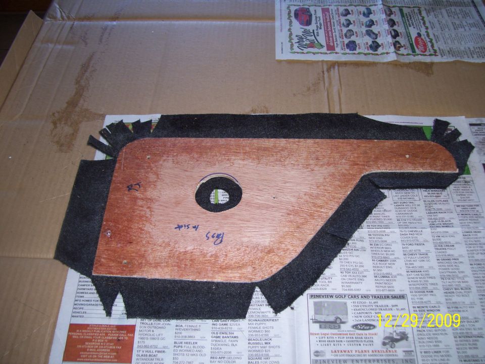 Interior door panel part with wood backing and black carpet