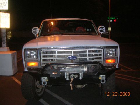 1985 Ford Bronco - Front view of a white 1985 Ford Bronco equipped with a winch and an aftermarket bumper.