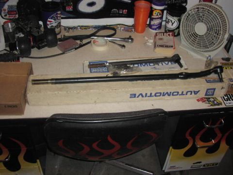 1981 Ford Bronco - Automotive steering parts are laid out on a desk next to tools and a desk fan.