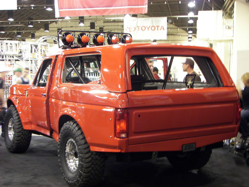 Orange Ford Bronco with roll cage and roof lights