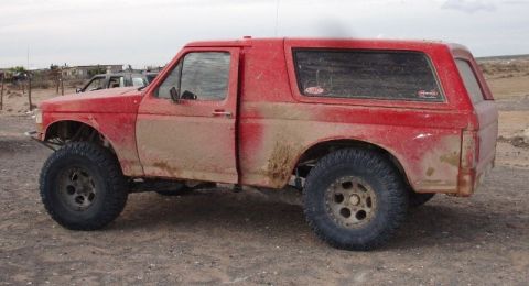 2006 Dodge 2500 - This red SUV with a camper shell appears to be a Ford Bronco from the early to mid-1990s, not a 2006 Dodge 2500.