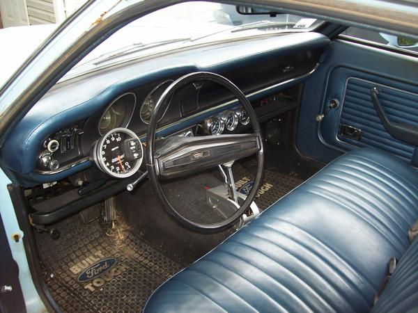 Blue vinyl interior of a 1973 Ford Maverick with a tachometer mounted on the dash