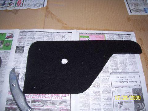 1978 Ford Bronco - A black carpet piece is being prepared on top of old newspapers, with a utility knife nearby.