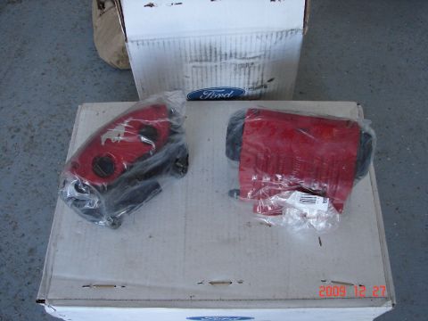 1995 Ford Bronco - Two red brake calipers are packaged on cardboard boxes, with one box displaying a Ford logo.