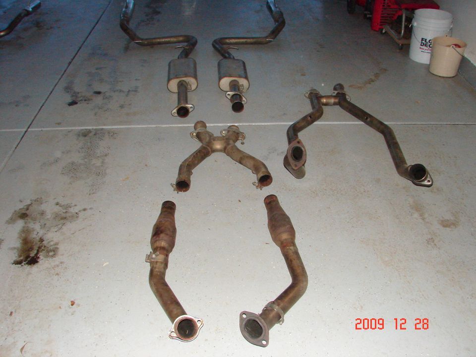 Exhaust system parts laid out on concrete floor