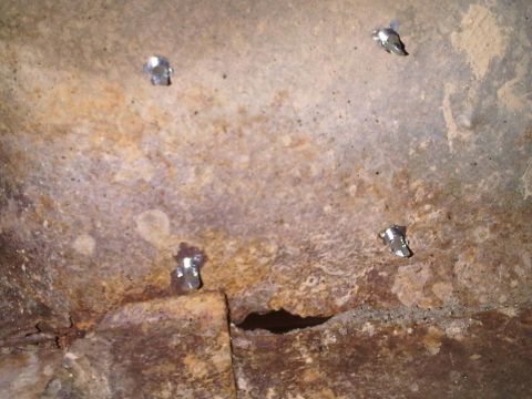 1996 Ford Bronco - Rusted metal surface with rivets and a hole, likely a structural component.