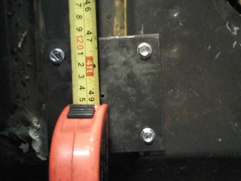 1996 Ford Bronco - A close-up view of a metal plate and a measuring tape, indicating measurements in inches.