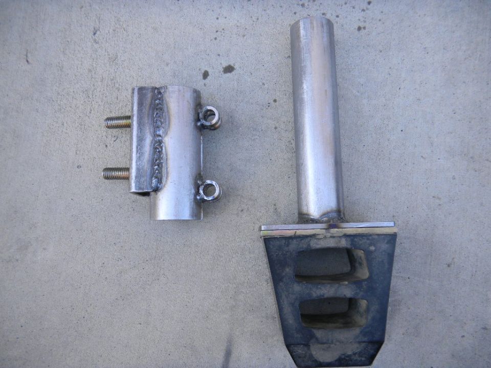 Two custom metal parts, one with bolts and loops, the other a tube welded to a rubber block