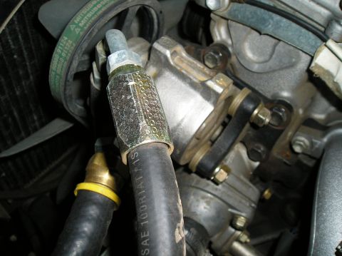 1986 Toyota Hilux - Close-up view of engine components, including a hose and a fan belt.