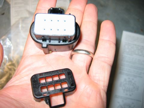1992 Ford Bronco - A person's hand holds a two-piece black electrical connector, showing an 8-pin male connector with a white face and blue-dotted terminals a…