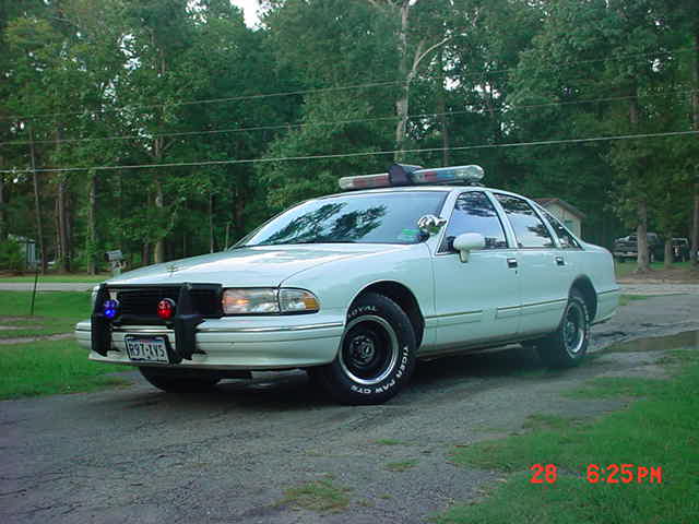 White 2003 Ford Crown Victoria police car with a push bumper and light bar