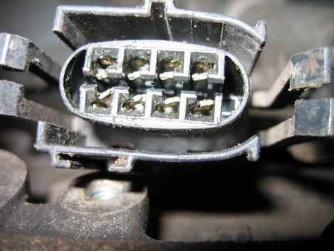 1992 Ford Bronco - Close-up of a multi-pin electrical connector, likely a plug or socket, showing eight metal terminals arranged in two rows within a black pl…