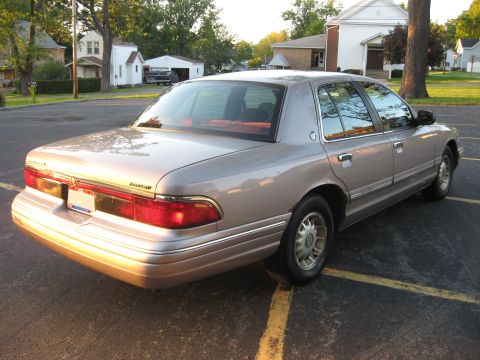 1995 Mercury Grand Marquis - Rear view of a tan 1995 Mercury Grand Marquis parked in a lot.