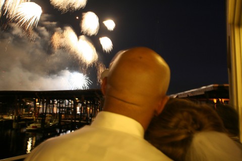2008 Ford F-250 - Two people watch fireworks over a body of water with a building in the background.