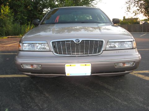 1995 Mercury Grand Marquis - Front view of a tan 1995 Mercury Grand Marquis, its chrome grille and headlights.