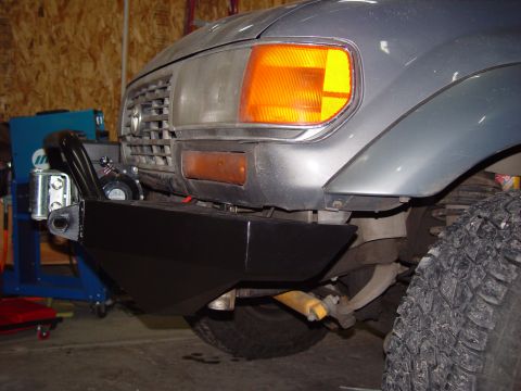 1993 Ford Bronco - Close-up of the front of a gray Toyota Land Cruiser, showing an aftermarket bumper and winch installation.