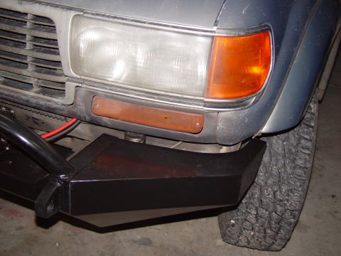 1993 Ford Bronco - Close-up of a vehicle's front end, focusing on the bumper and headlight.