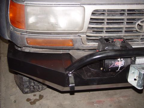 1993 Ford Bronco - Aftermarket front bumper with a winch installed, obscuring the vehicle's grille and headlights.