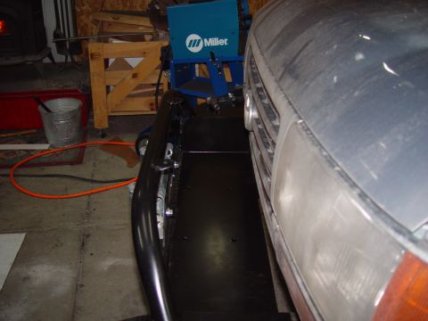 1993 Ford Bronco - Close-up of a vehicle's front end, with a custom bumper installed. A welding machine is visible in the garage setting.