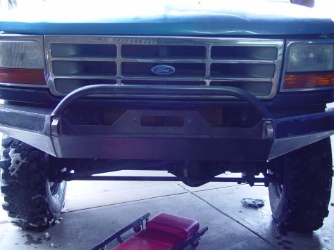 1993 Ford Bronco - Front view of a blue Ford truck with a chrome grille and an aftermarket bumper.