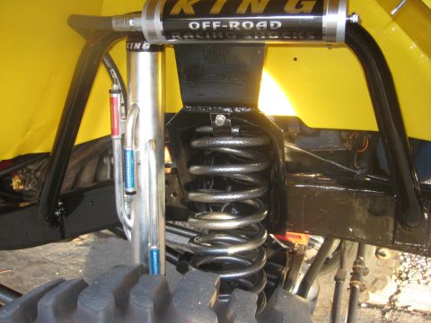 1970 Ford Bronco - Close-up view of King Off-Road Racing Shocks and suspension components on a yellow vehicle.