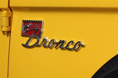 1970 Ford Bronco - Close-up of the 'Bronco Sport' emblem on a yellow vehicle.