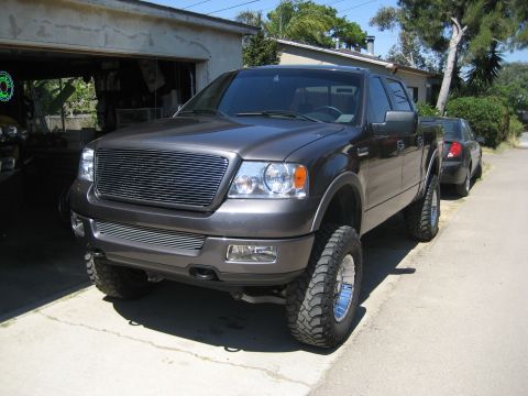 2005 Ford F-150 - This lifted 2005 Ford F-150 features a custom chrome grille and aggressive off-road tires.