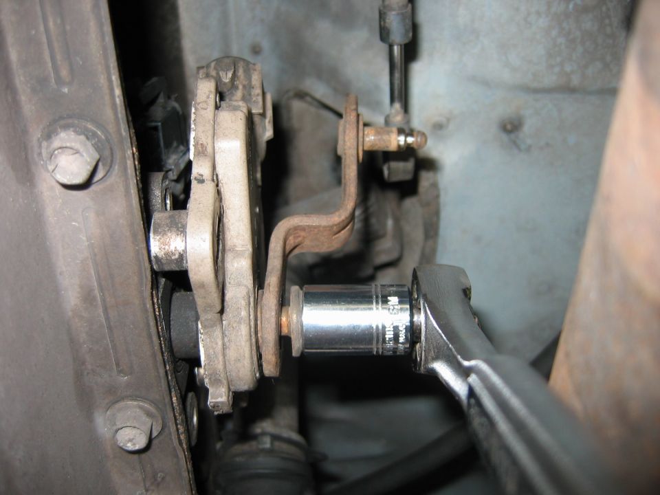 Chrome socket on bolt near rusty bracket during undercarriage repair