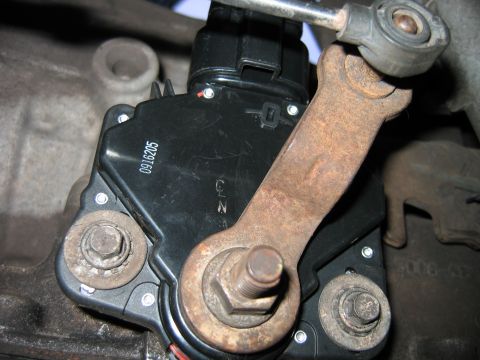1992 Ford Bronco - Close-up of a black transmission range sensor (neutral safety switch) mounted on a transmission, with a rusted external shift lever arm and…