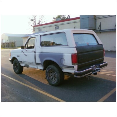 1989 Ford Bronco - This 1980s Ford Bronco is seen from the side, showing its two-tone paint and aftermarket wheels.